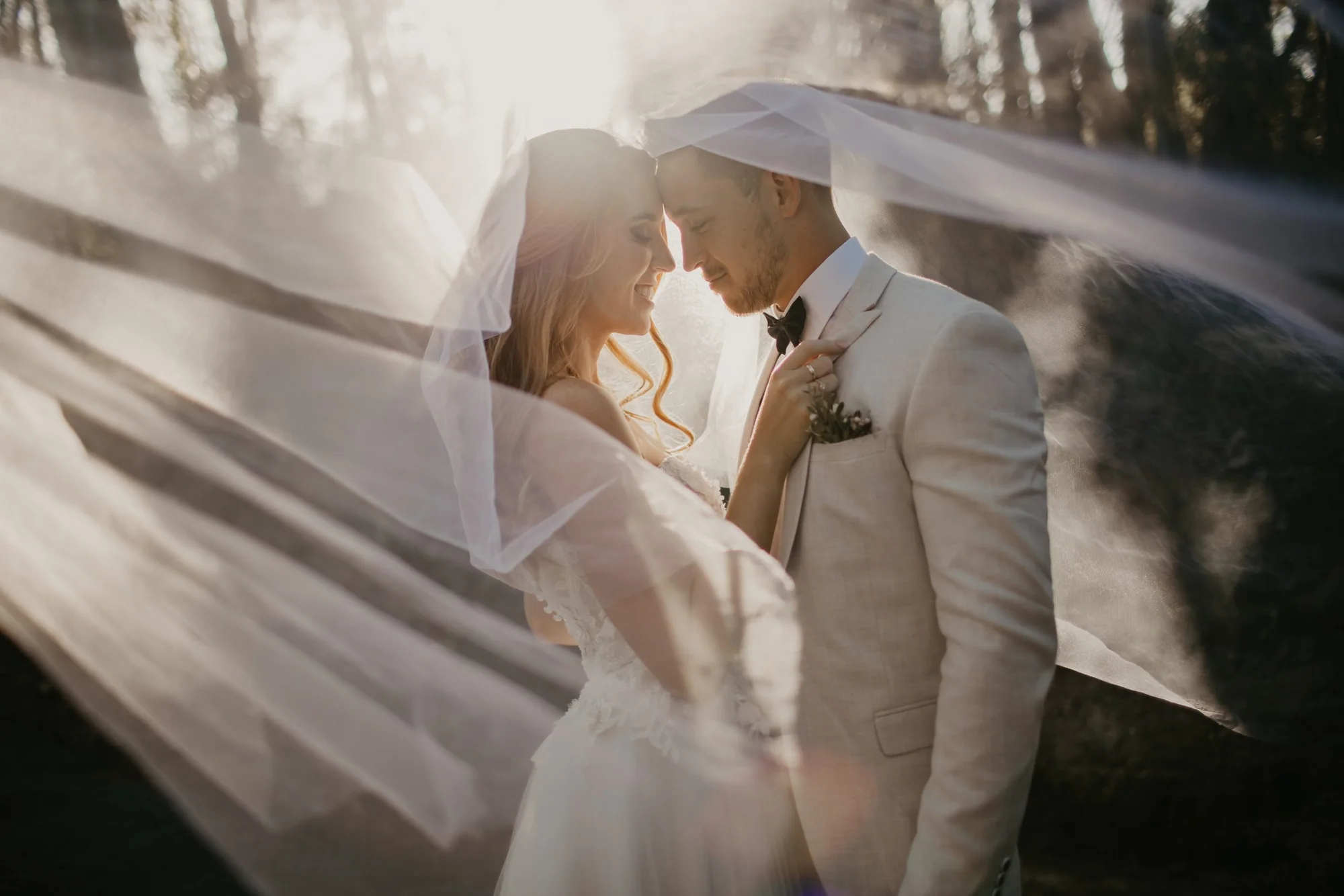 Newlyweds beneath a flowing wedding veil